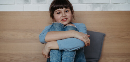 Portrait of cute young girl. Girl with long hair sitting at home. Banner with copy space.