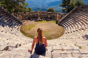 Fototapeta premium Traveler woman sitting in amphitheatre in Turkey- Antalya, Arykanda
