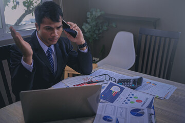 Businessman using smartphone seriously talking from business disappointed by bad business results....