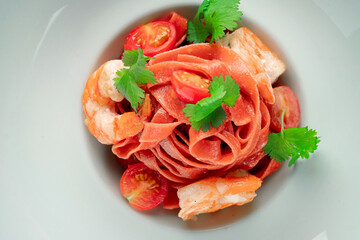 Classic homemade pasta with colored tagliatelli, cherry tomatoes