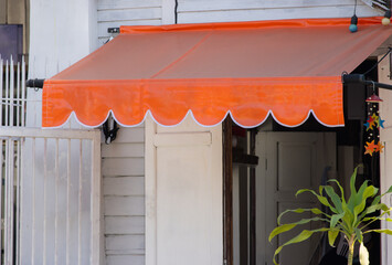 A white building with an orange awning