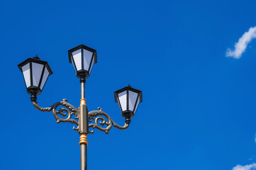 modern street lamp in vintage style on the background of clear blue sky in day