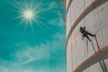 Male worker down height tank roof rope access safety inspection thickness weld of storage tank
