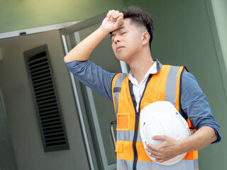 Dizziness and migraine headache from overworked exhaustion or heat stroke. Tired Asian male worker...