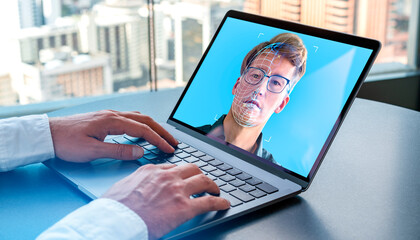 Businessman using laptop with biometric scanning hologram, face swapping