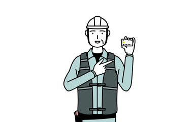 クレジット決済を勧めるヘルメットと作業着姿のシニア男性技師