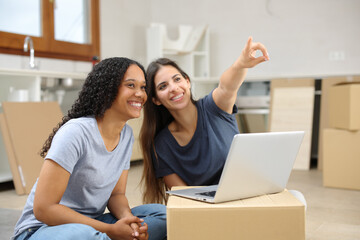 Two happy roommates planning decoration moving home