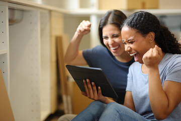 Excited women in a house under reform checking tablet