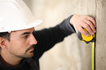 Construction worker using measuring meter