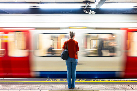 Woman standing near moving train at metro station