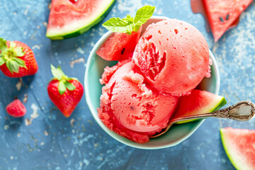 Refreshing watermelon sorbet served in a black bowl, garnished with mint leaves.