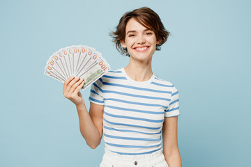 Young happy fun woman wearing striped t-shirt casual clothes hold in hand fan of cash money in...