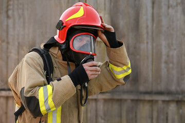 Firefighter in uniform wearing helmet and mask outdoors