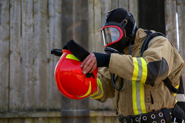 Fototapeta premium Firefighter in uniform wearing helmet and mask outdoors