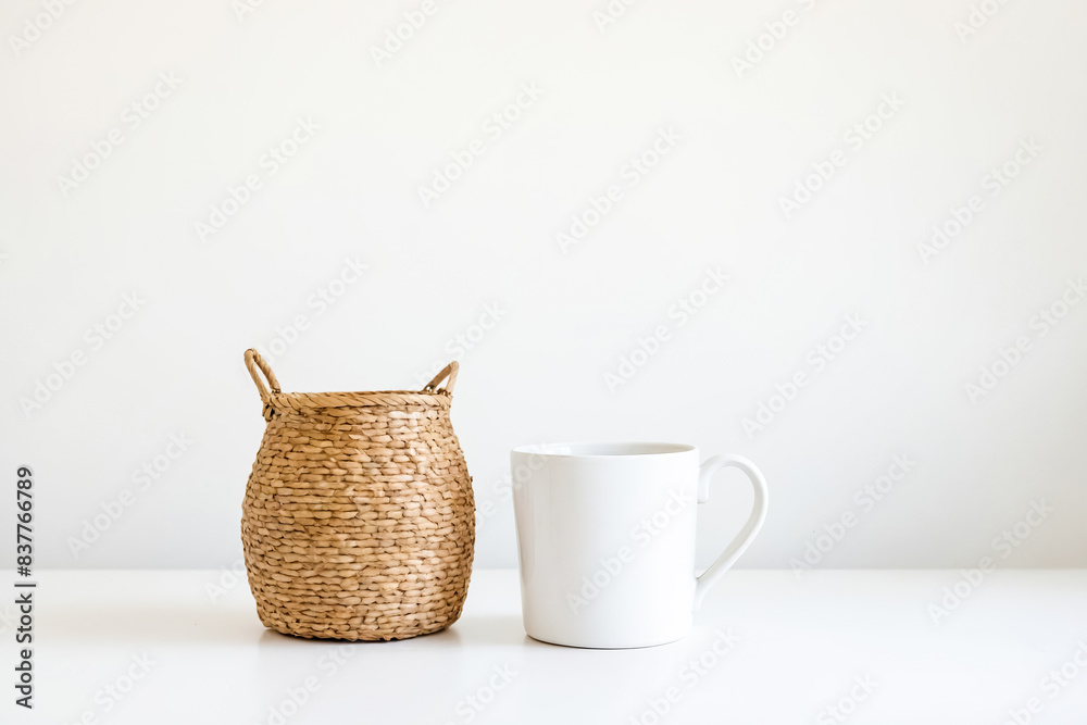 Wall mural Wicker Basket and White Mug on White Table