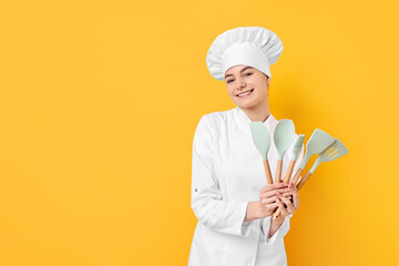 Professional chef with kitchen utensils on yellow background. Space for text