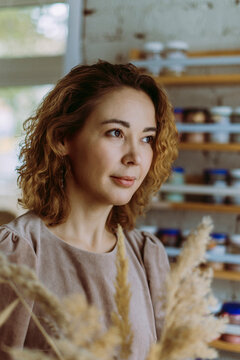 Smiling businesswoman with pampas grass at workshop