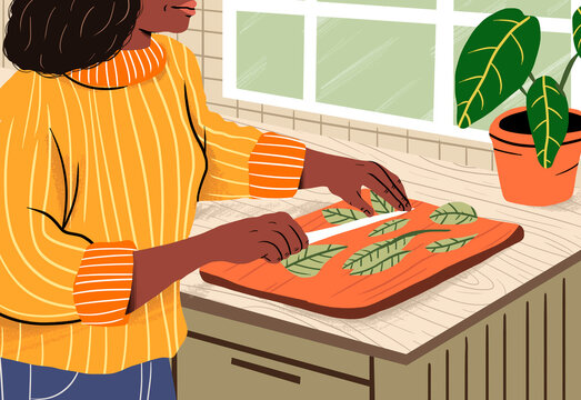 Woman chopping vegetables on cutting board in kitchen at home