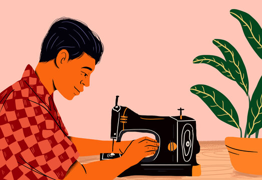 Tailor with sewing machine sitting near table against colored background