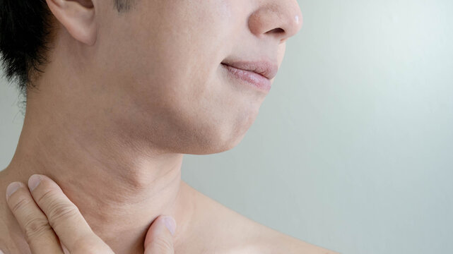 Half face of Asian man touching his neck checking skin crease wrinkles. Facial complexion treatment and rejuvenation by skincare and cosmetic cream. Mens beauty cosmetology. Anti aging concept