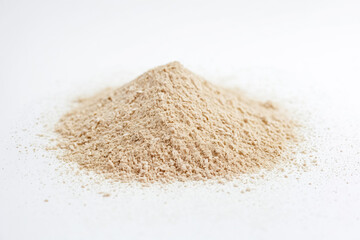 Close-up of a pile of granulated brown powder on a white background