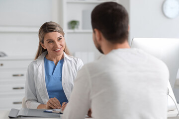Fototapeta premium Professional doctor working with patient at white table in hospital