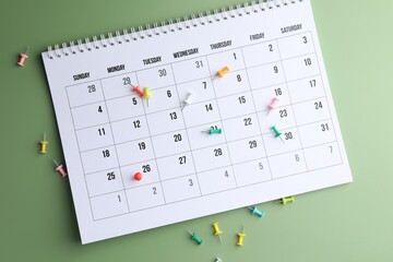 Timetable. Calendar and drawing pins on green background, top view