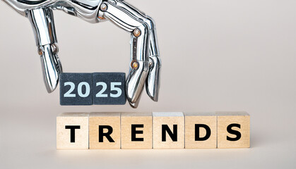 Robot hand holds the expression '2025 trends'. Symbol for even more artificial intelligence in the year 2025.