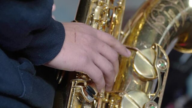 Closeup of a tenor saxophone plater's right hand during a performance.