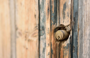 Old wooden door with modern door lock cylinder close-up