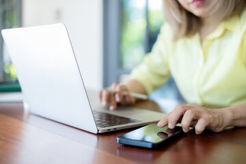 Business woman sitting in office at table and using smartphone