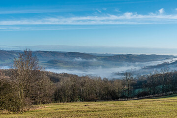 view from a hill in Ceske Stredohori with blue sky and fog