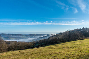 view from a hill in Ceske Stredohori with blue sky and fog