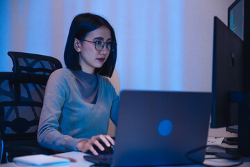 Asian woman  software development working on coding  computer screen and flowchart at night in...