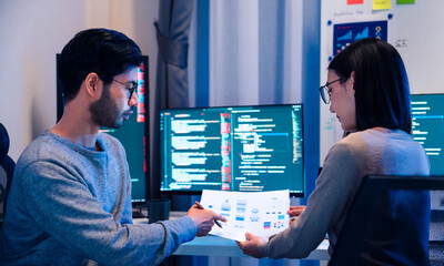 Asian software developers teams working on multiple screens displaying code and application...