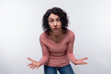 Confused angry european adult woman with curls on white background with copy space