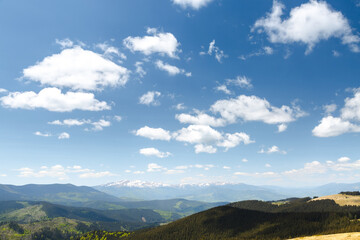 Spacious grThe snow-capped peaks of the mountain range can be seen in the distance. Carpathian mountains, Ukraine.