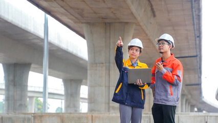 Asian male and female engineers Inspecting construction work radio command concrete road bridge...