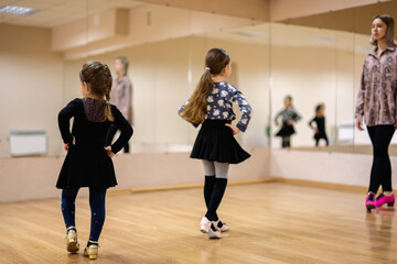 Fototapeta premium Young Girls Attending Dance Class with Female Instructor in Studio