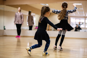 Young Girls Practicing Dance with Instructor in Studio