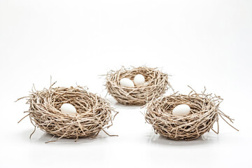 Three Bird Nests With Eggs on White Background