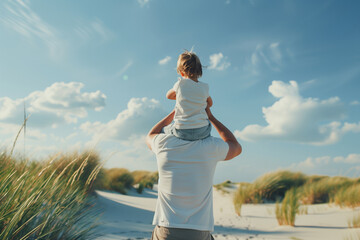 Back view of a father holding his child on his shoulders at the beach