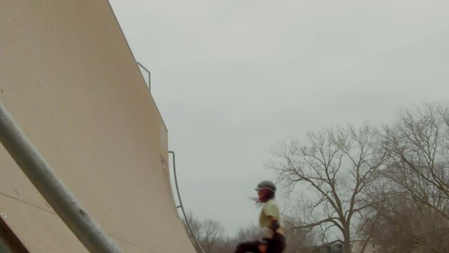 Slow motion static shot of quad skater on a foggy day jumping on a 15 foot half pipe. Corey Lawrence Vert Ramp in Lawrence, KS.
