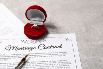 Marriage contract, fountain pen and ring with gemstone on grey table