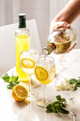 Making The Limoncello Spritz cocktail, combination of limoncello, sparkling wine and soda with...