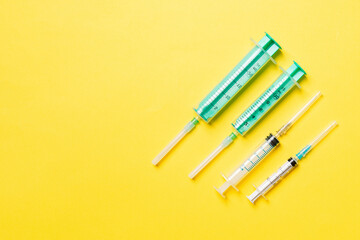 Top view of syringes in a row for medical injection on colorful background with copy space. Health and vaccination concept