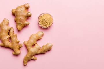 Finely dry Ginger powder in bowl with green leaves isolated on colored background. top view flat lay