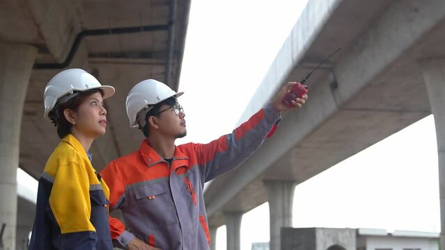 Asian engineering team Inspecting construction work radio command concrete road bridge highway