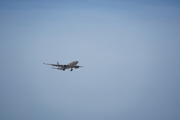 Airplane is flying in the sky with the landing gear down