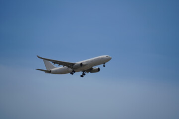 Airplane is flying in the sky with the landing gear down